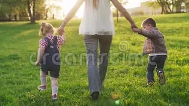 在日落时分，妈妈和孩子们<strong>手拉手</strong>一起在草地上奔跑